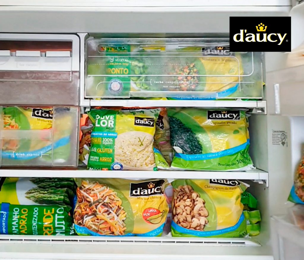 Freezer aberto com diversos pacotes de legumes congelados Daucy