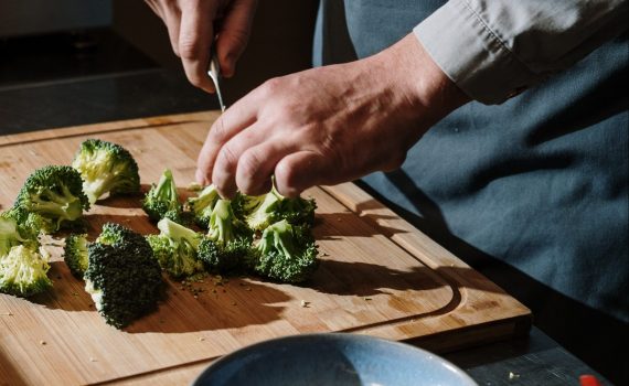 Mão cortando brócolis